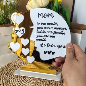 Close-up of white and gold acrylic Mother's Day plaque with heart cutouts and personalized poem