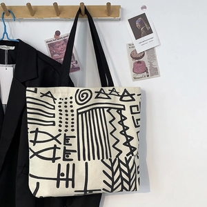 Detail of minimalist canvas tote with black abstract art print and long shoulder straps