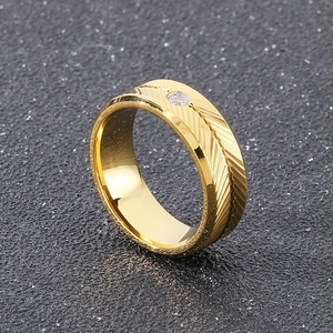Detailed view of gold feather engraved ring with a centered round zircon stone