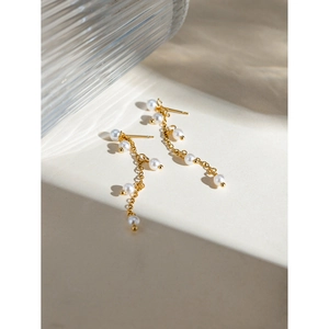 Detail of 18K gold stainless steel earrings with elegant white grape-shaped pearls