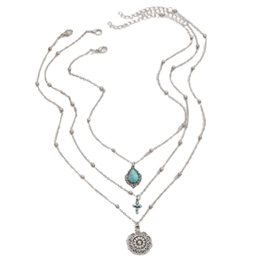 Dettaglio della collana boho a tre strati con pendenti in turchese e croce