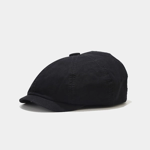 Detailed close-up of retro black cotton newsboy cap showing fine stitching and fabric texture