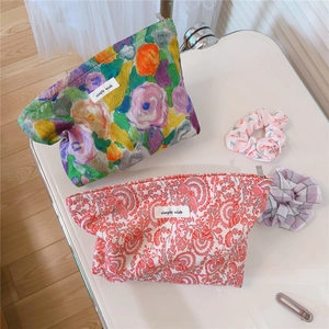 Detailed view of floral cotton makeup bags with simple wish label and hair accessories