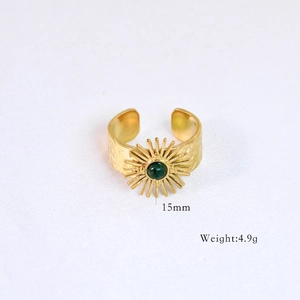 Detailed macro shot of vintage gold sunburst ring featuring a round green gemstone