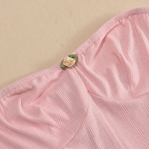 Detail of pink knitted dress neck with ribbed texture and delicate floral embroidery