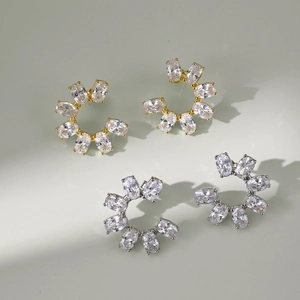 Macro detail of gold and silver flower stud earrings with marquise zircon stones
