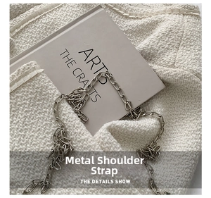 Close-up of the elegant silver chain shoulder strap and textured floral fabric detail