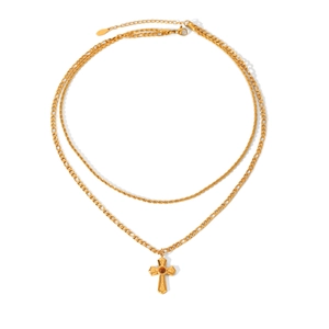 Close-up of gold double-layer necklace featuring a cross pendant with a dark gemstone