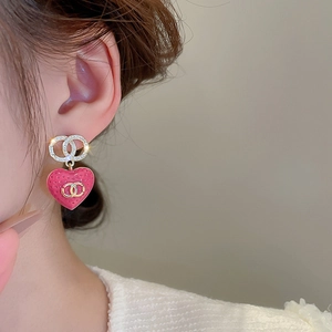 Detail view of heart-shaped earrings with pink texture and sparkling double-C logo accents