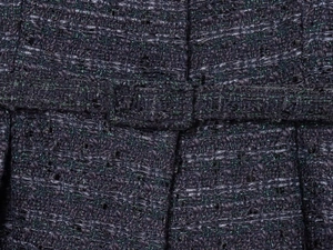 Macro de tissu tweed violet foncé avec fils métalliques verts et détails de passants