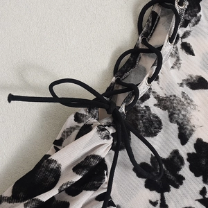 Détail du laçage et du tissu en maille florale d'une robe nuisette courte et sexy