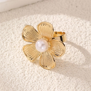 Macro view of golden flower ring with central pearl and vintage petal texture details
