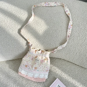 Détail du sac à cordon avec motifs d'ours et broderie délicate en dentelle blanche