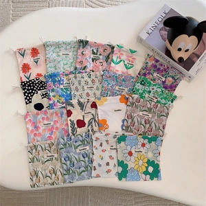 Flat lay of assorted floral and patterned fabric drawstring storage pouches on white surface