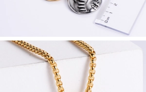 Macro detail of 2cm silver sun face pendant and golden ball chain with scale measure