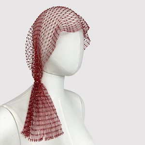 Detailed close-up of red mesh headpiece with sparkling crystal rhinestones on grid