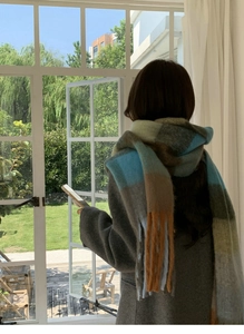 Detail of colorful plaid scarf with fringes and thick mohair texture for winter warmth