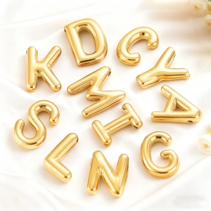 Gold 18K stainless steel bubble letter pendants on white silk background for DIY jewelry