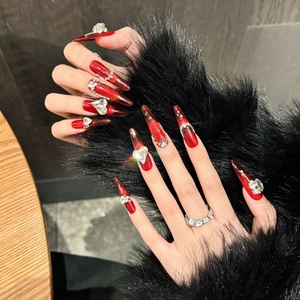 Unghie finte rosse cat eye a stiletto con strass a cuore e decorazioni brillanti