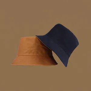 Detail of double-sided cotton sun hats in caramel and navy with wide sun protection brims