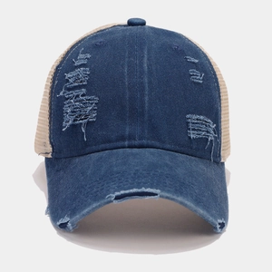 Close-up of distressed denim baseball cap featuring vintage frayed holes and breathable mesh