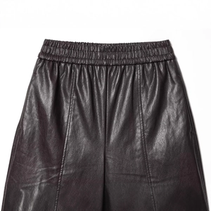 High-waisted faux leather shorts with elastic waistband and decorative stitching detail