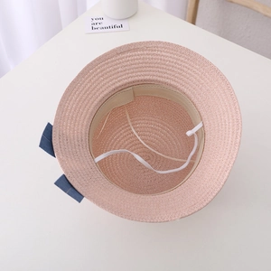 Pink straw sun hat for girls featuring inner sweatband, chin strap and blue bow detail