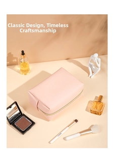 Pale pink faux leather makeup bag with gold zipper shown with cosmetic accessories