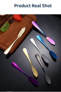 Sieben bunte Buttermesser aus Edelstahl auf einem Holzbrett mit frischen Früchten serviert