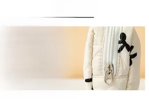 Close-up of smooth metal zipper on cream quilted sanitary pad storage pouch