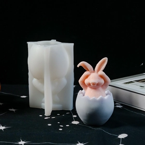 Dettaglio dello stampo in silicone bianco e scultura di coniglio rosa che esce dall'uovo