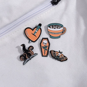 Gothic enamel pin set with skull, heart, and octopus designs on white canvas background