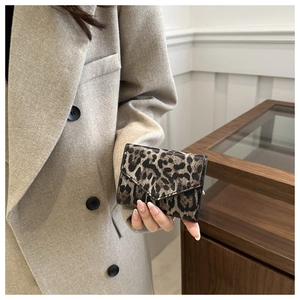 Close-up of leopard print envelope wallet held by hand for a stylish accessory detail