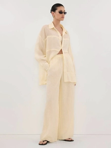 Minimalist beige linen two-piece set featuring a long sleeve shirt and wide leg trousers