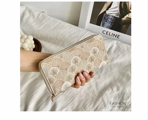 Chic long zipper wallet with gold fan embroidery held by a model in a minimal setting
