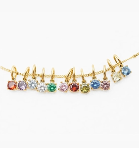 Macro detail of twelve colorful birthstone pendants on a gold stainless steel chain