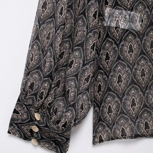 Damen-Schiffonbluse mit geometrischem Muster und goldenen Knöpfen an den Ärmelbündchen