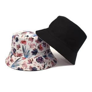Women's reversible cotton bucket hat in black and colorful floral print with sun protection