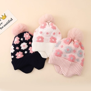 Winter floral knitted hat for girls with warm fleece lining and pompom ear flaps