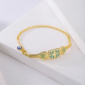 Böhmisches 18K vergoldetes Armband mit blauen Evil Eye Anhängern auf Stein-Hintergrund