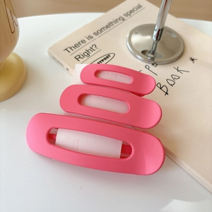 Detailed view of three pink matte hair clips in small, medium, and large sizes