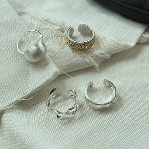 Macro shot of S925 sterling silver rings with textured matte and wavy engraved patterns