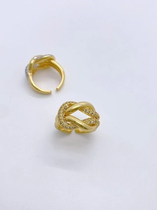 Detailaufnahme goldener Knotringe mit funkelndem Zirkonia-Besatz und offener Form