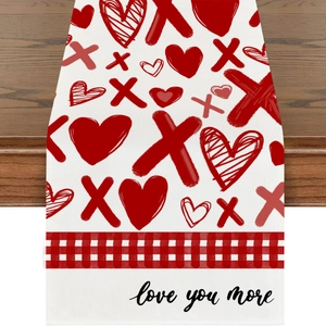Close-up of linen Valentine's table runner with XOXO pattern and 'love you more' text