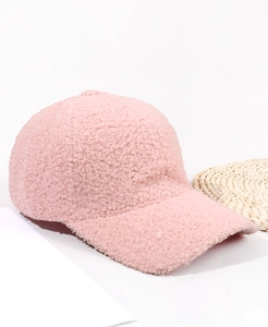 Detail of pink teddy fleece baseball cap showing soft textured plush fabric and curved brim