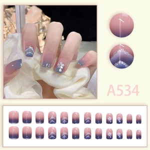 Detail view of pink and blue gradient press-on nails set with floral accents, model A534