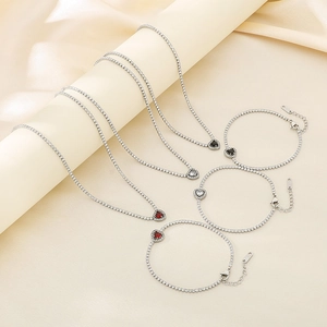 Detailed shot of heart jewelry set with black white and red zircon stones in silver finish