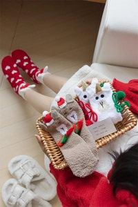 Close-up of cozy coral fleece Christmas socks featuring festive patterns and cute animal designs