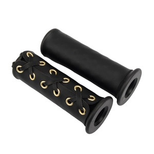 Detail of black leather motorcycle handlebar grips with decorative lace-up design and eyelets