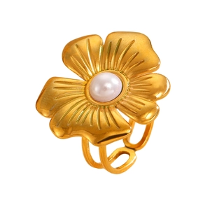 Detailed macro view of vintage gold flower ring with pearl center and textured petals